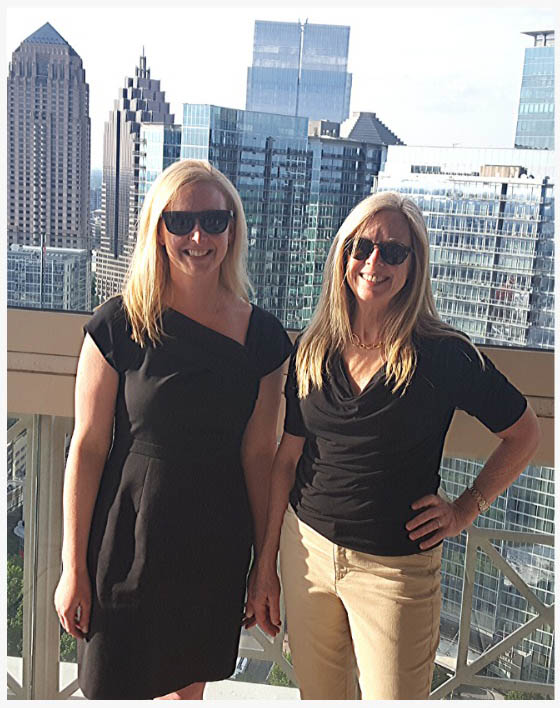 Equita Financial Network founders Katie Burke and Bridget Venus Grimes stand outside on city patio